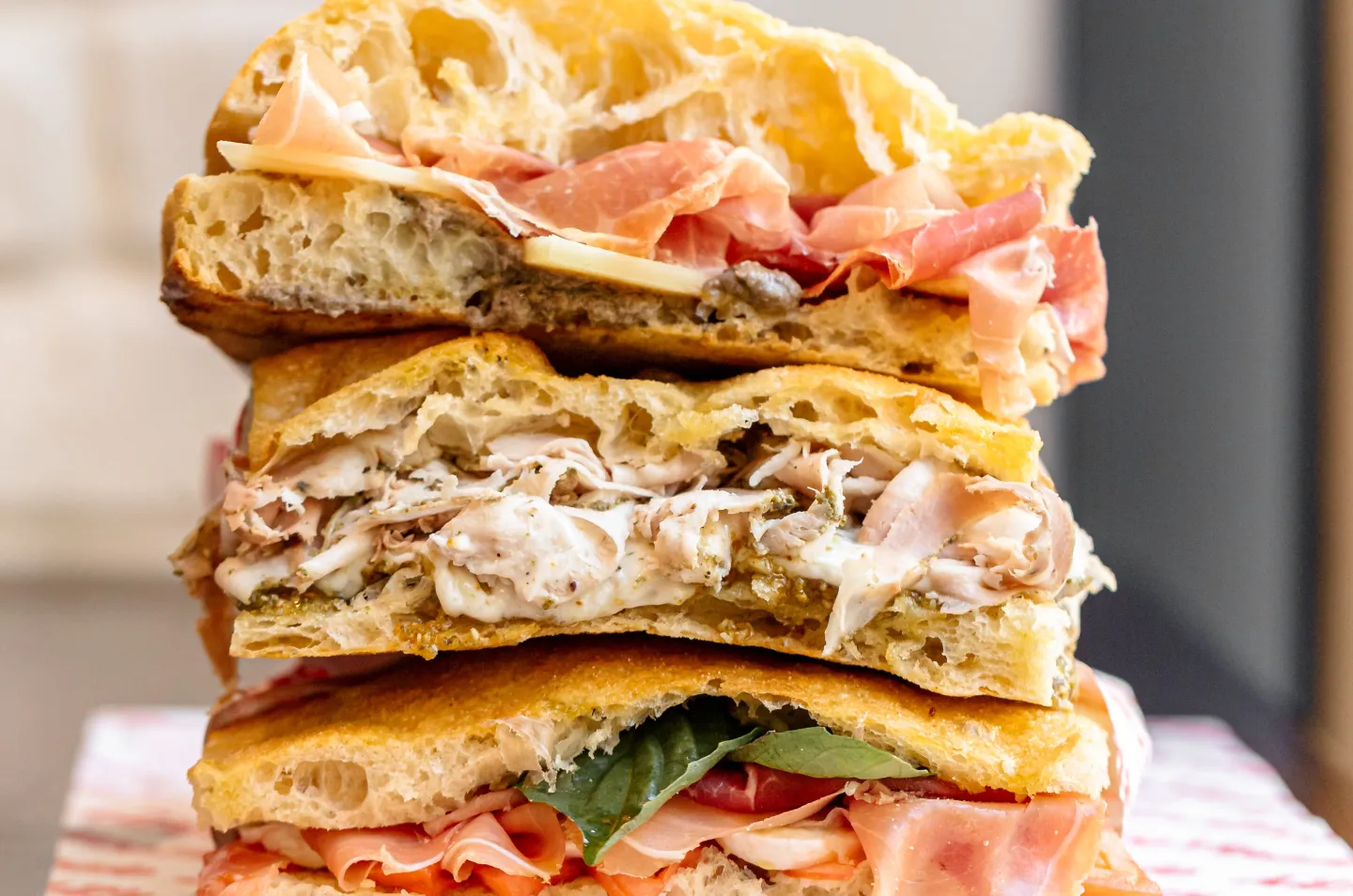 Stack of Italian sandwiches with prosciutto, fresh mozzarella and basil